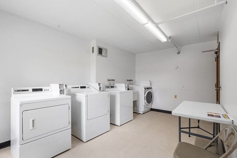 a laundry room with washers and dryers and a table