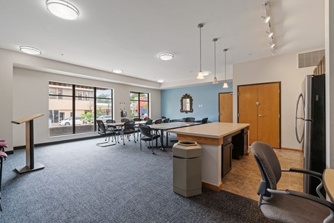 a conference room with a table and chairs and a refrigerator
