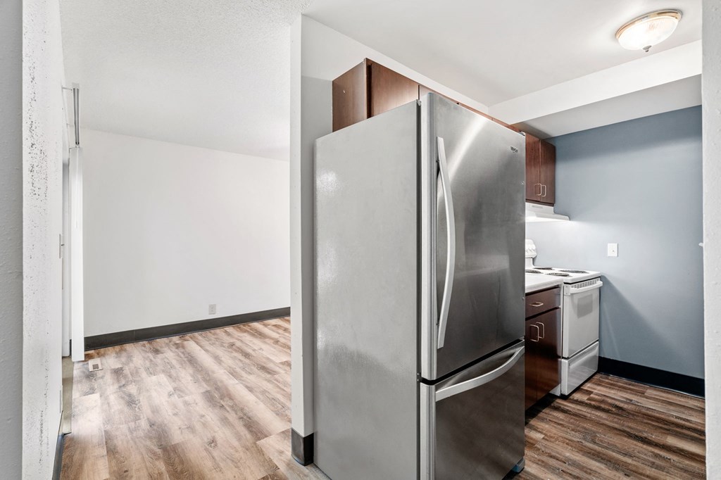 a renovated kitchen with stainless steel refrigerator and white appliances