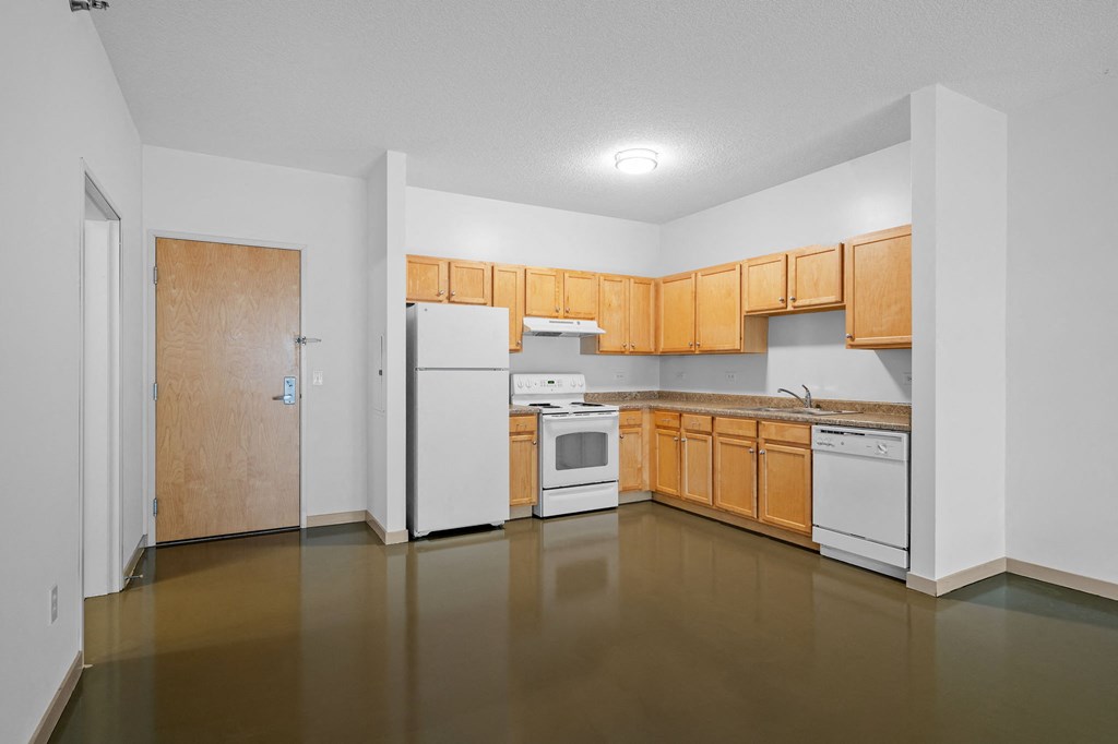 an empty kitchen with white appliances and wood cabinets