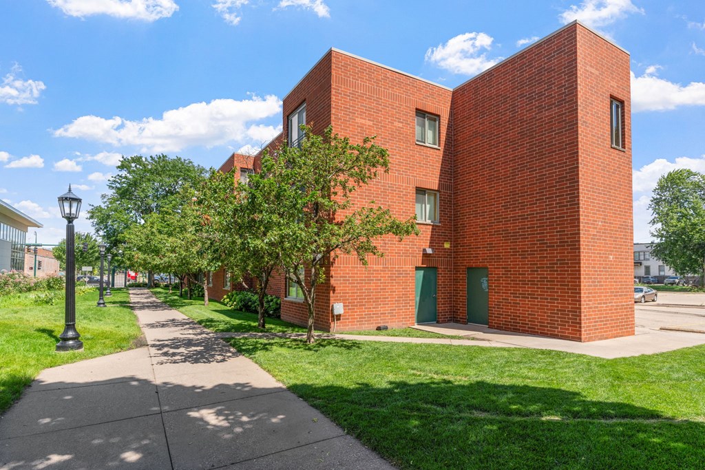 a red brick building with a sidewalk in front of it