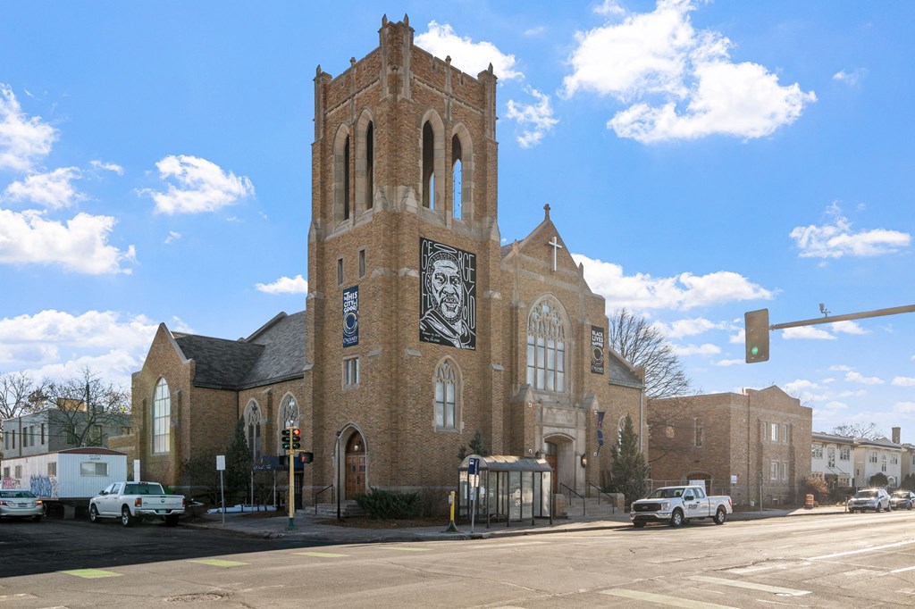 a church with a clock tower on the side of a street