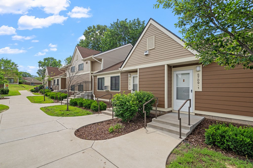 a row of houses with stairs and a sidewalk