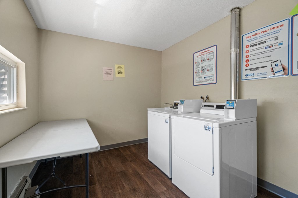 a laundry room with two washing machines and a table