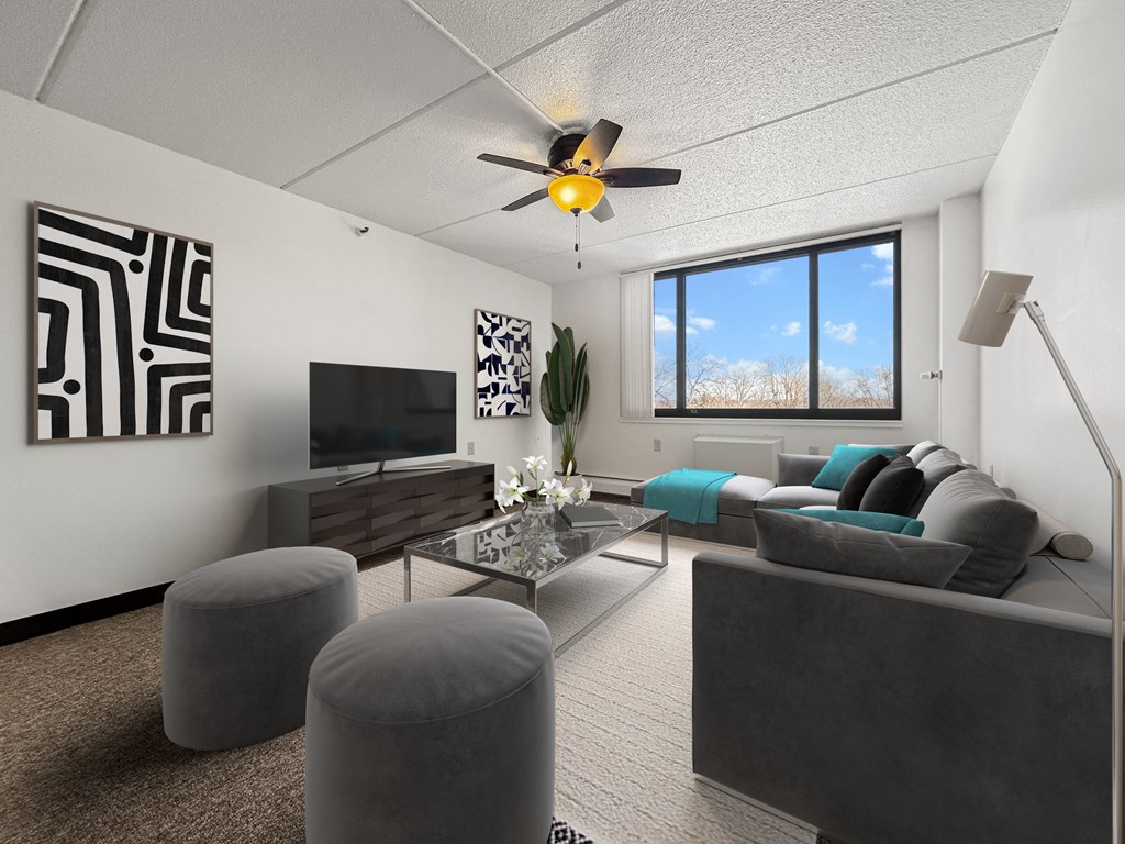 an open living room with a large window and a ceiling fan