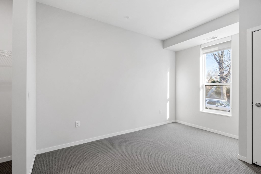 an empty room with white walls and a window