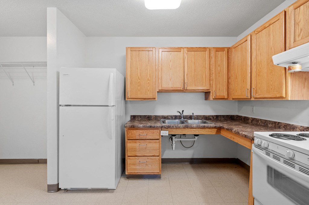 an empty kitchen with a sink and refrigerator