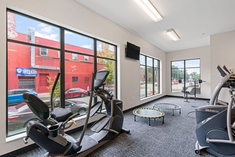 a gym with exercise equipment and large windows