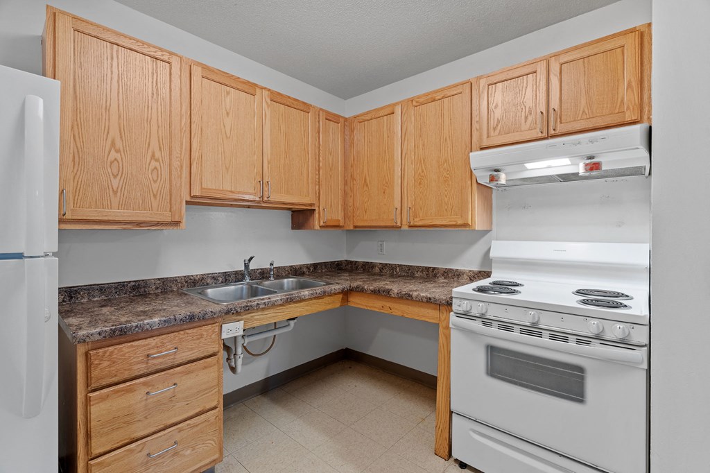 a kitchen with white appliances and wooden cabinets