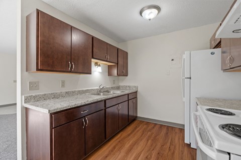 a kitchen with wooden cabinets and a white stove and refrigerator