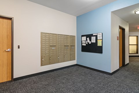 a wall of mailboxes in a room with a door