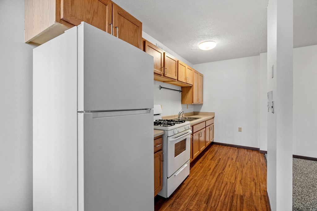 a kitchen with wood flooring and white appliances