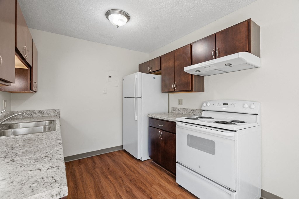 a kitchen with white appliances and wood flooring
