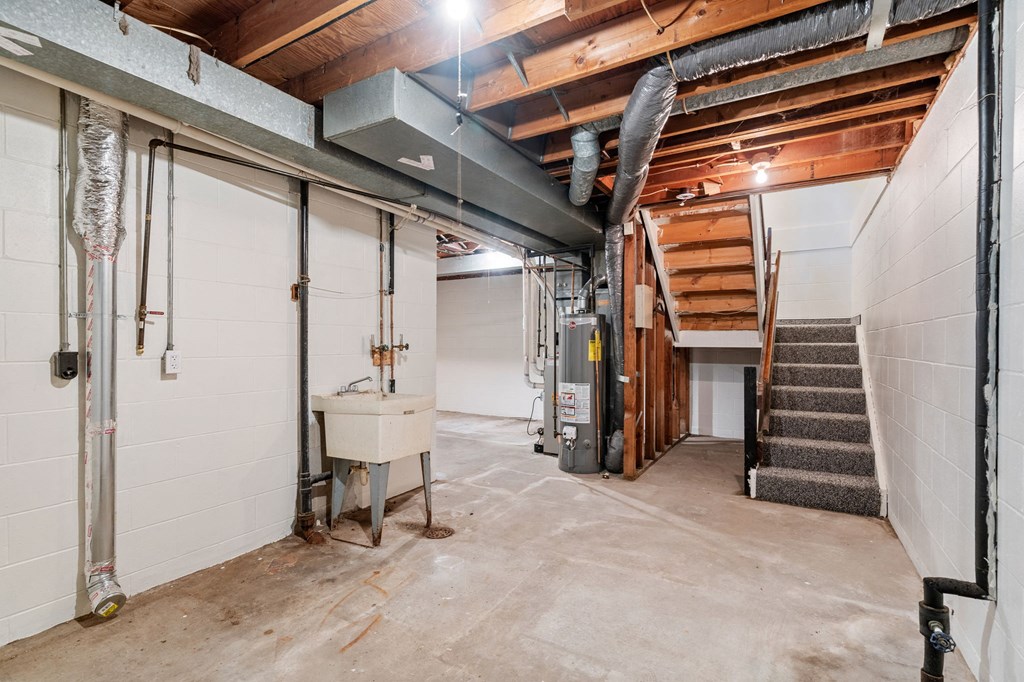 the basement of a house with a staircase and a garage door