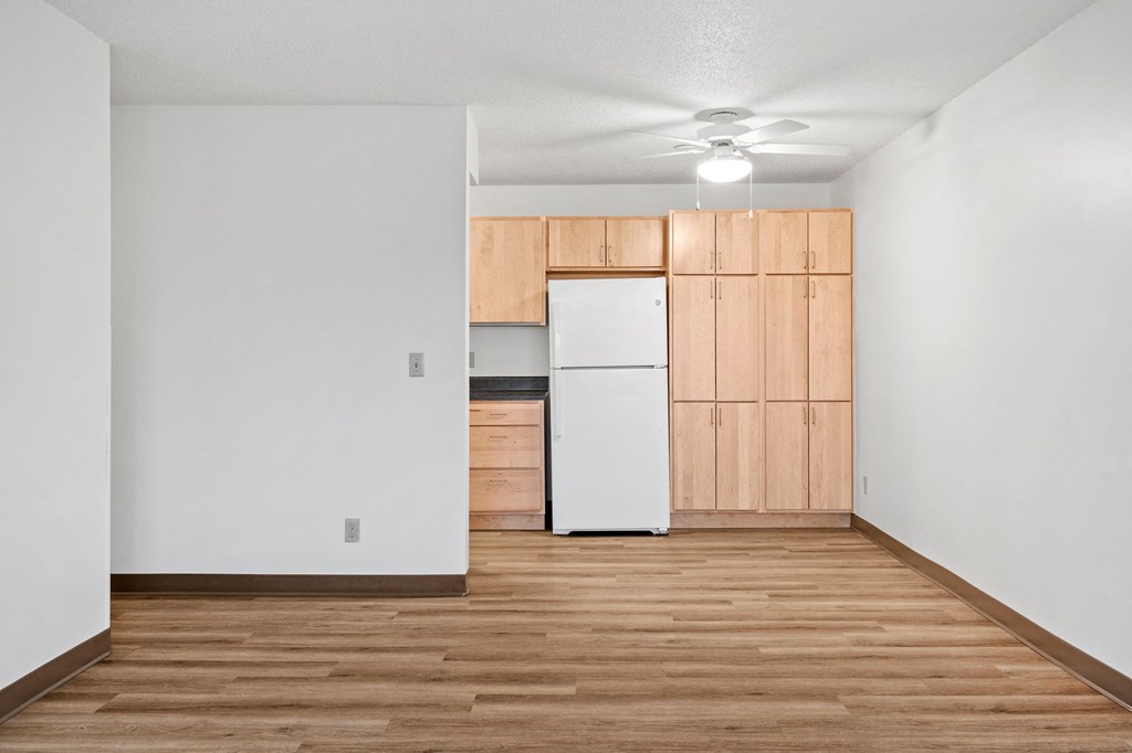 a kitchen with a white refrigerator and wooden cabinets