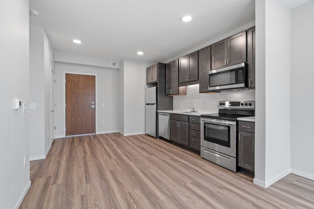 a renovated kitchen with wood flooring and stainless steel appliances