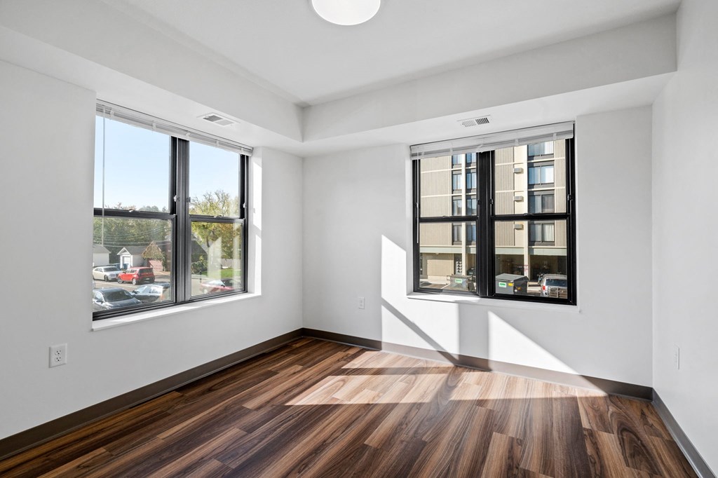 a living room with two windows and wood floors