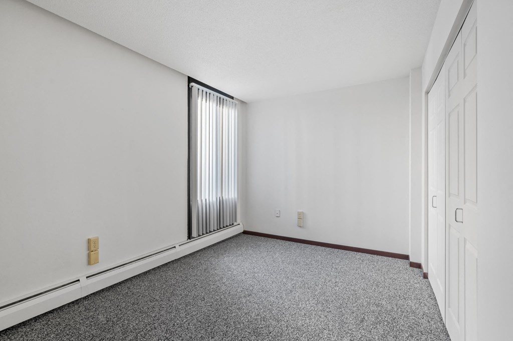 an empty room with carpet and a window