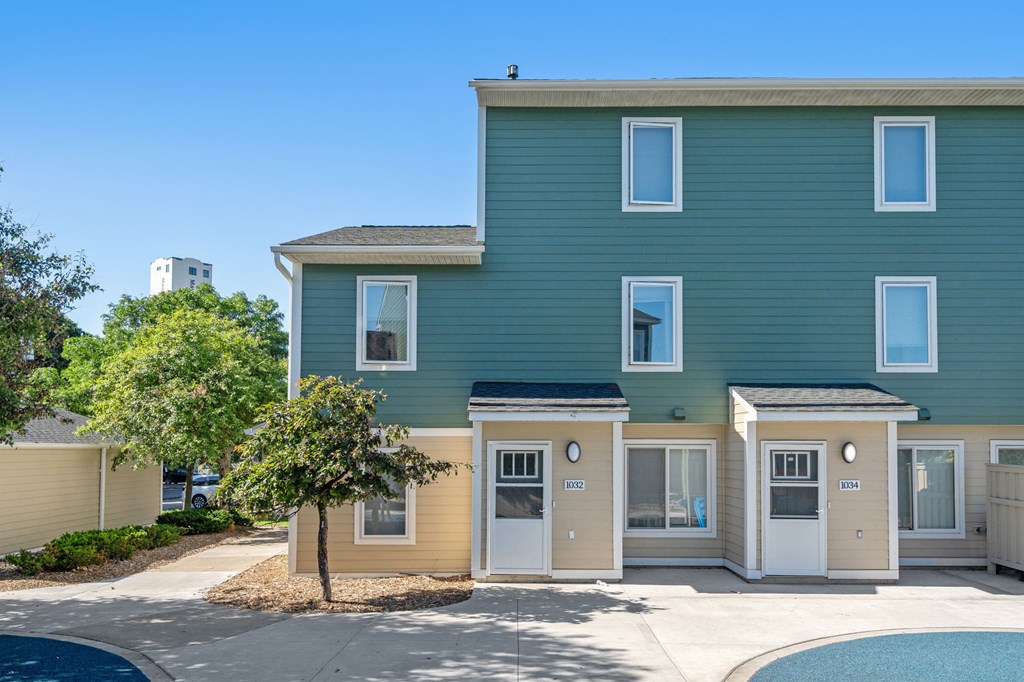 a green building with a tree in front of it