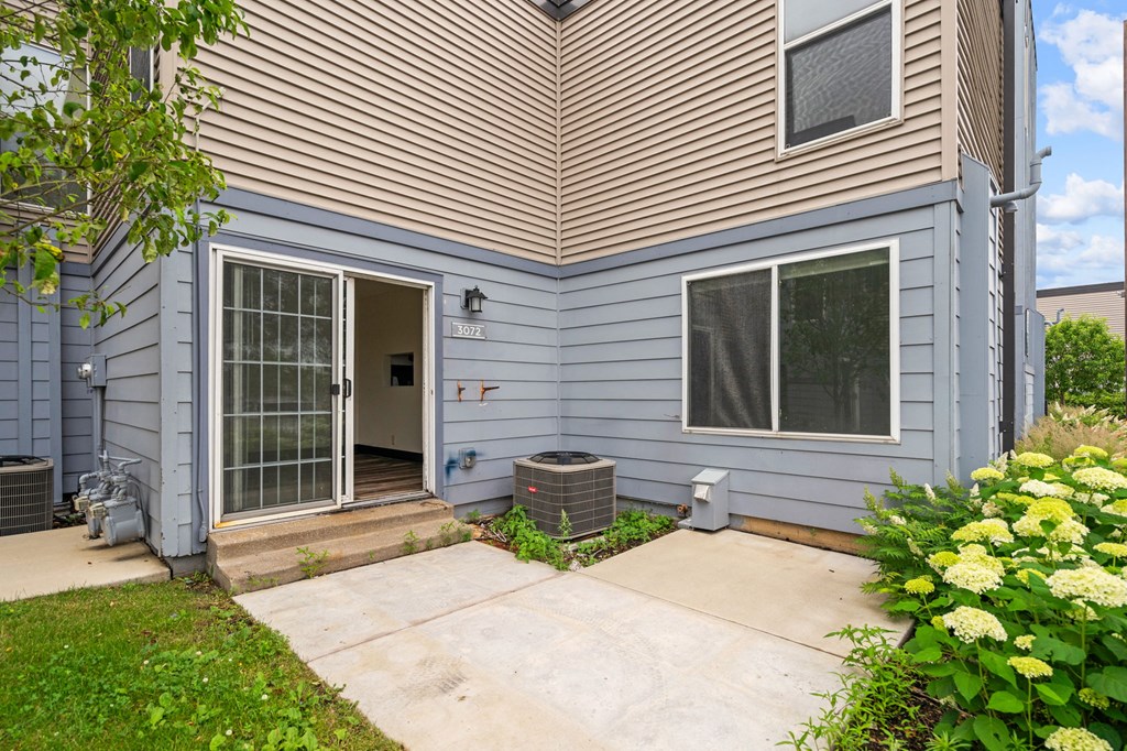 the back of a house with a patio and a backdoor