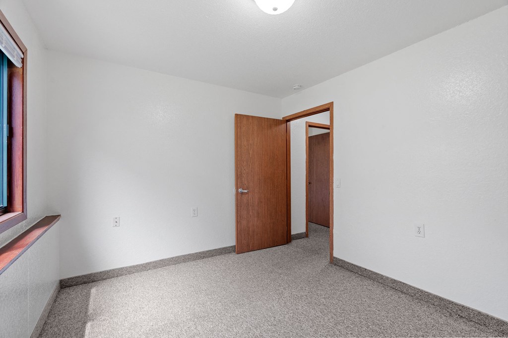 an empty room with white walls and a wooden door