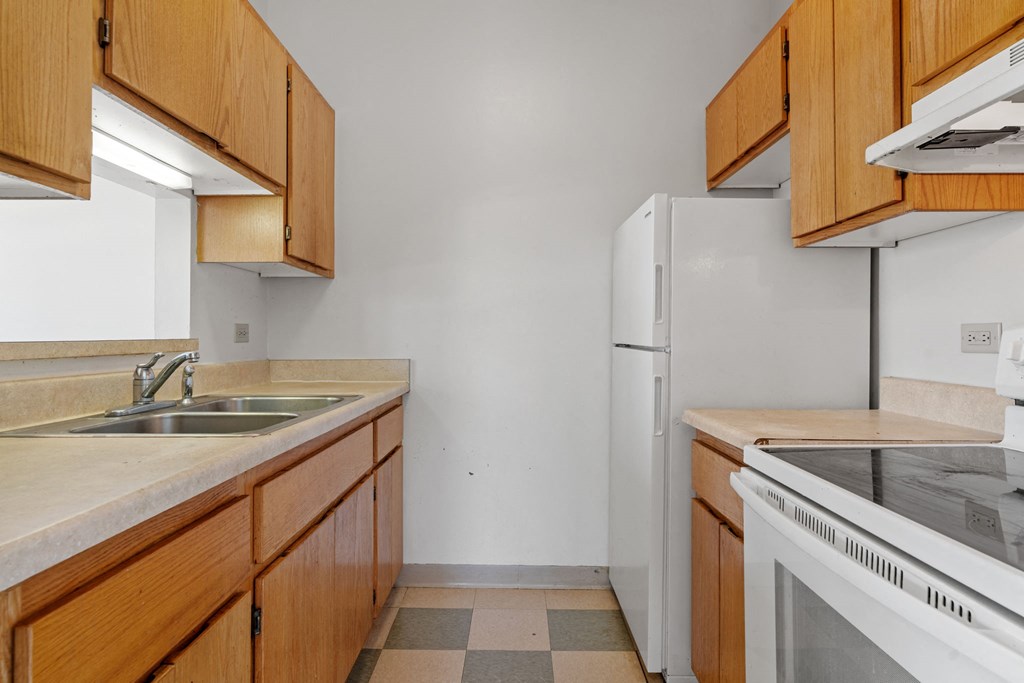 a kitchen with wooden cabinets and a sink and a refrigerator