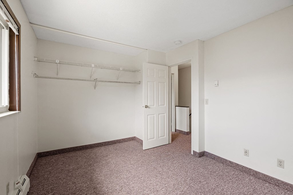 a bedroom with a closet and a door to a bathroom