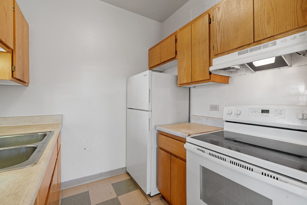 a kitchen with white appliances and wooden cabinets