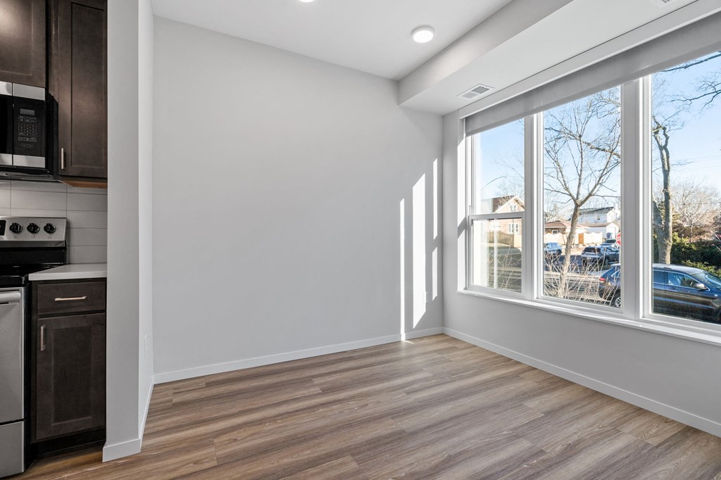 a living room with a large window and a kitchen