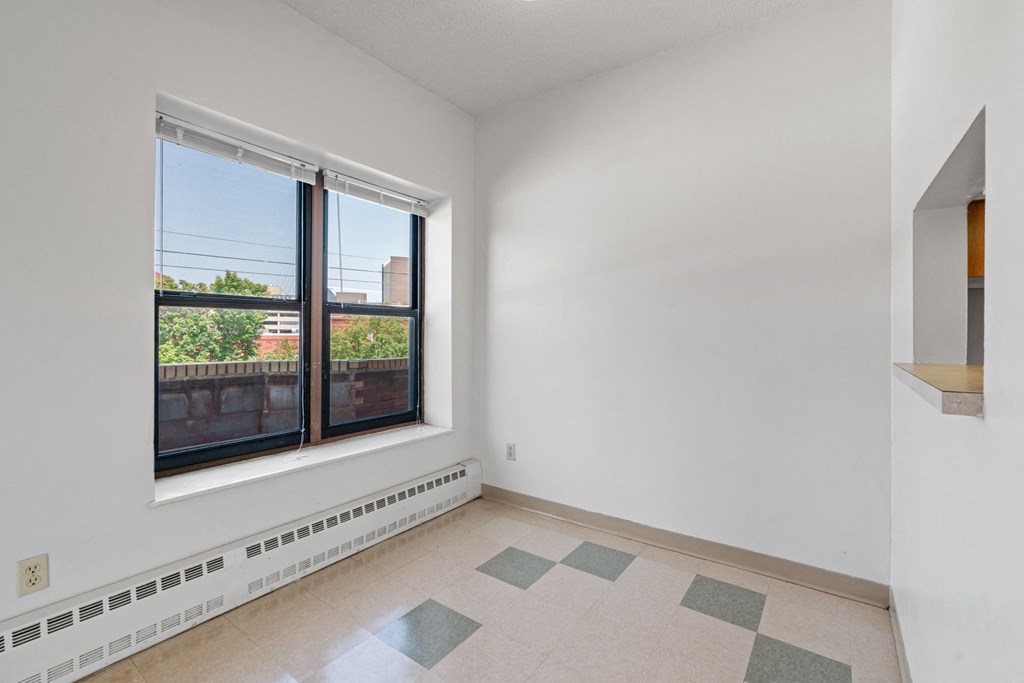 a living room with a large window and a tiled floor