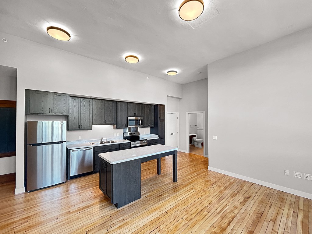 a kitchen with a island and a stainless steel refrigerator