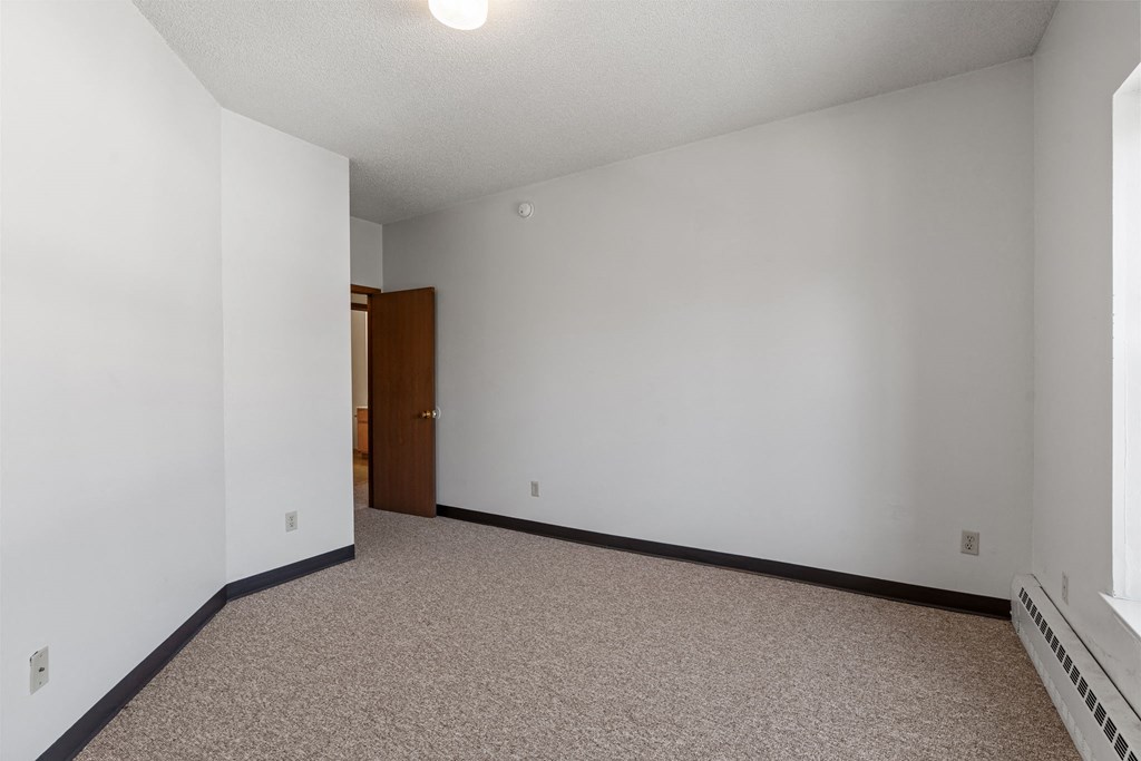 an empty room with white walls and a door to a bathroom