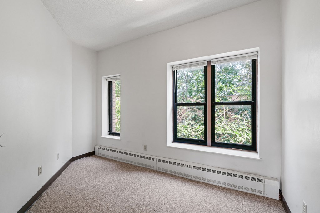 room with large windows and carpeting in a white room