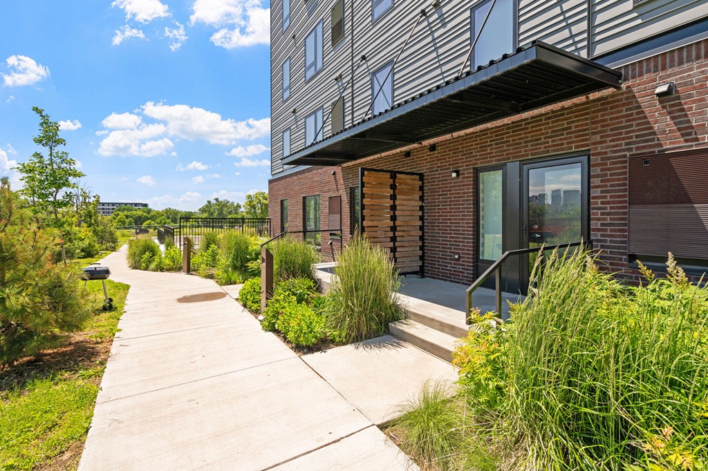 A modern building with a brick facade and a concrete walkway in front.