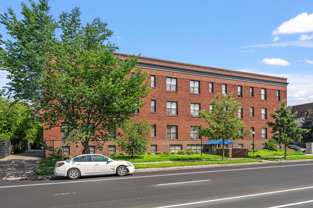 a red brick building with a white car parked in front of it