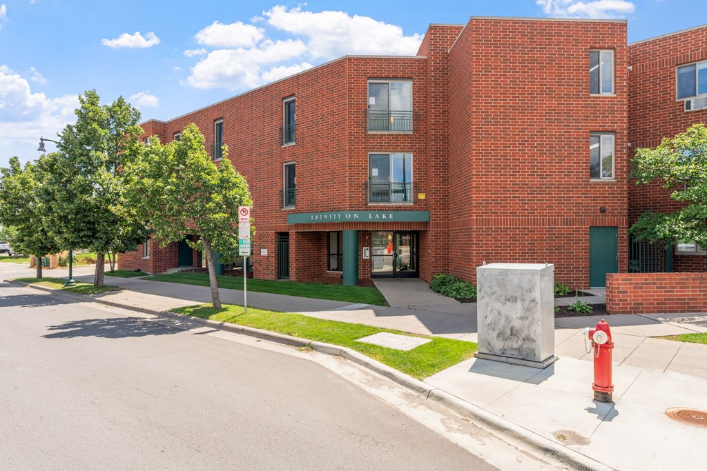 a red brick building with a sidewalk and a fire hydrant