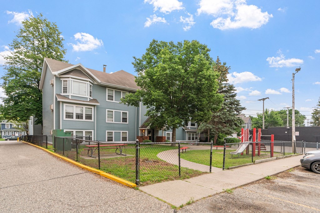 the view of a house with a playground in front of it