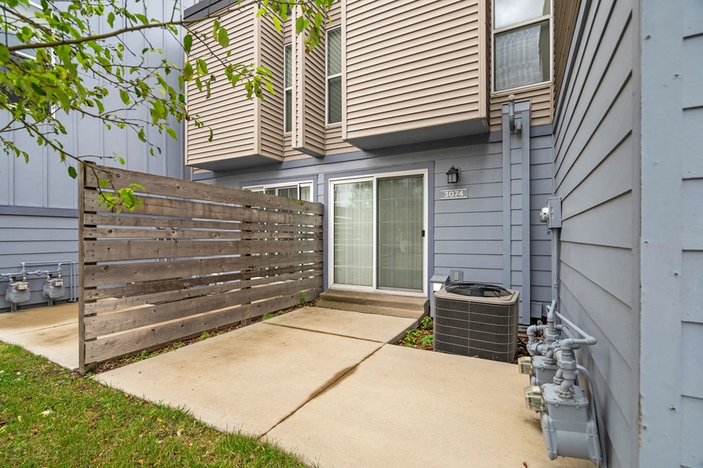 the front of a house with a wooden fence and a sidewalk