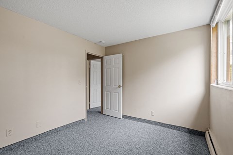 an empty bedroom with a door open to a closet