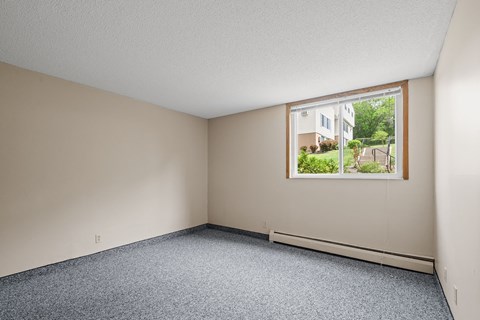 the living room of an empty house with a large window