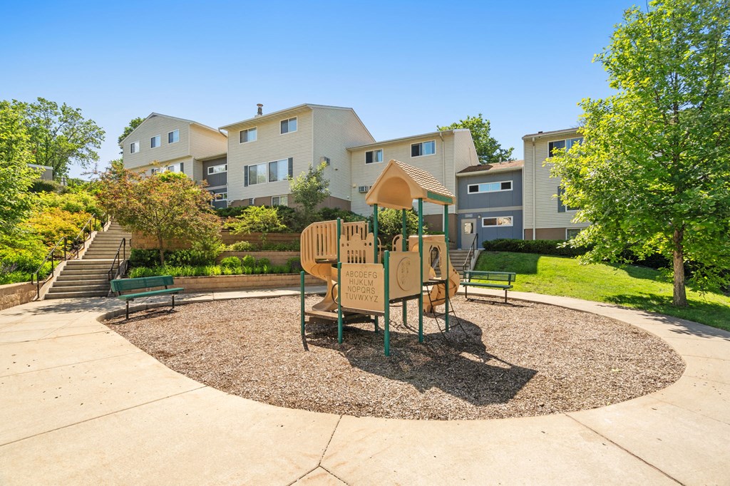 a playground with a table and chairs in front of some apartments
