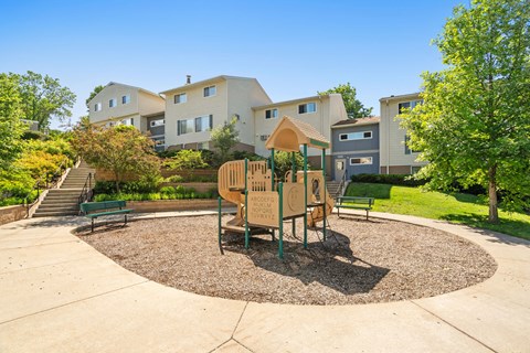 a playground with a table and chairs in front of some apartments