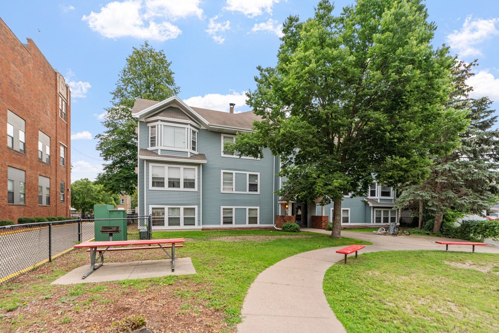 a park with a bench in front of an apartment building