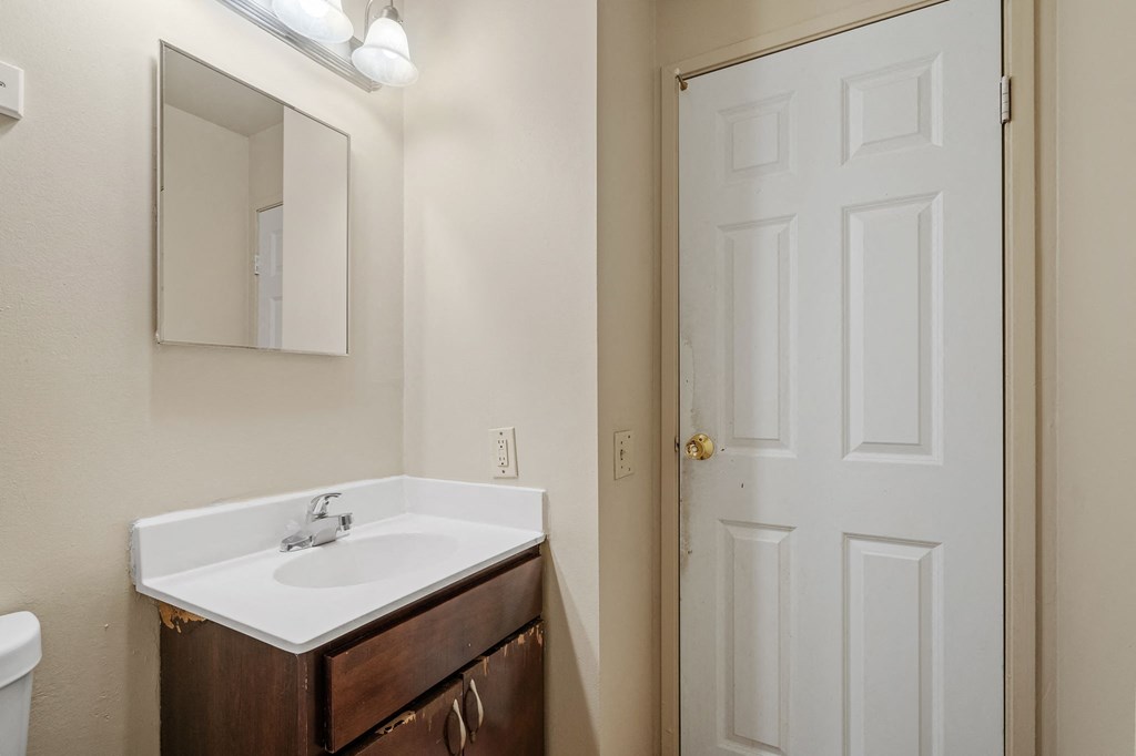 a bathroom with a sink and a mirror and a door