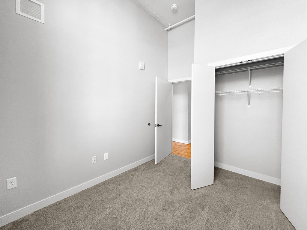 an empty bedroom with a closet and a door to the bathroom