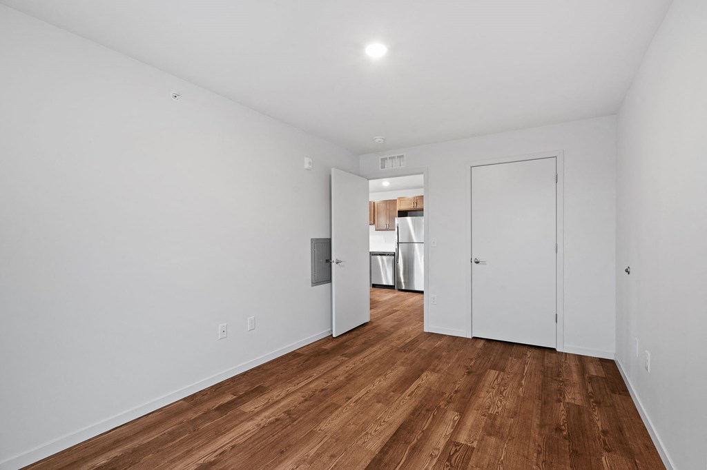 a living room with white walls and wood floors