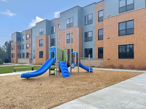 a playground in front of an apartment building