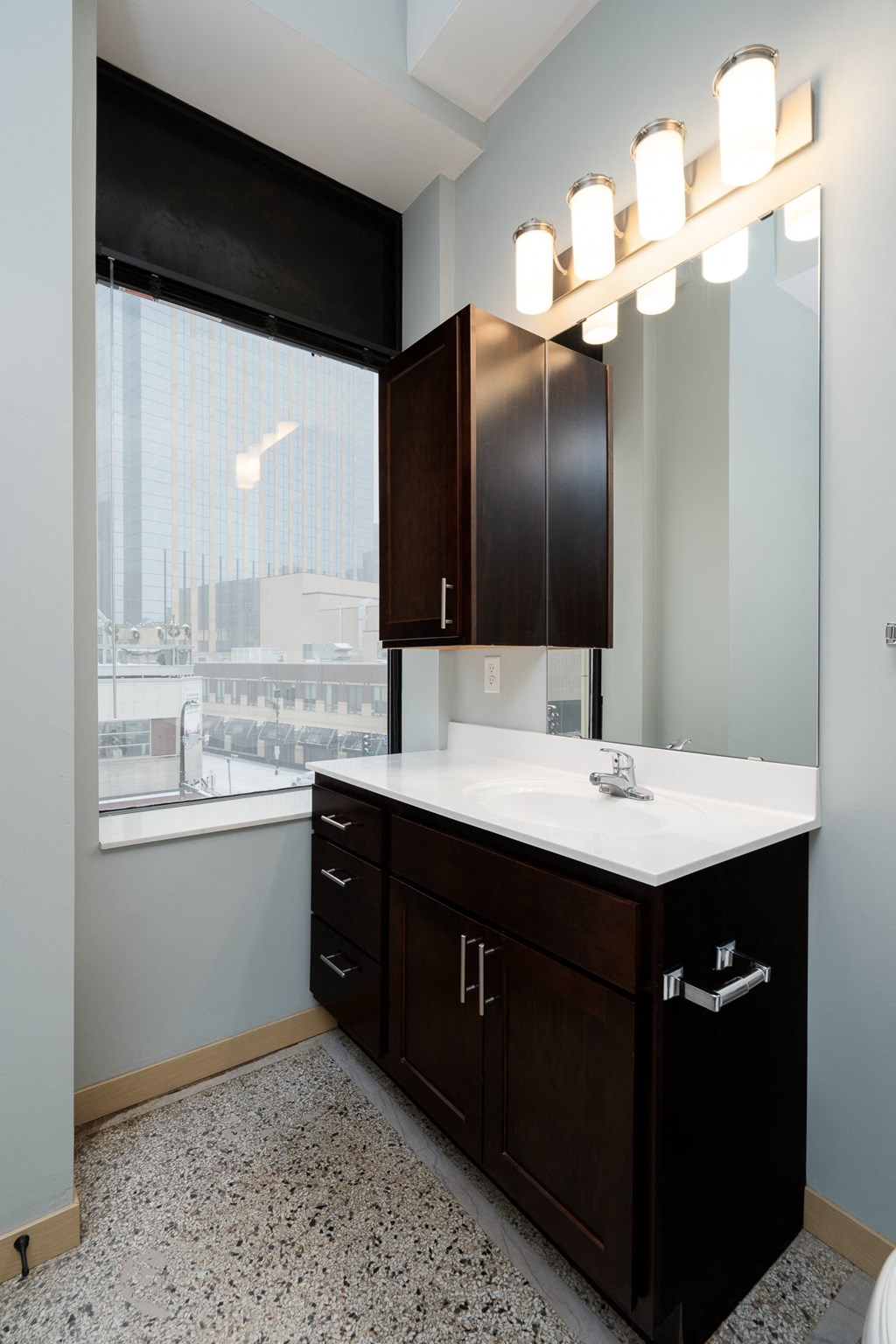 a bathroom with a large window and a sink and a mirror