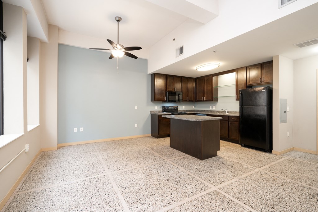 a kitchen with black appliances and a counter top in a new home