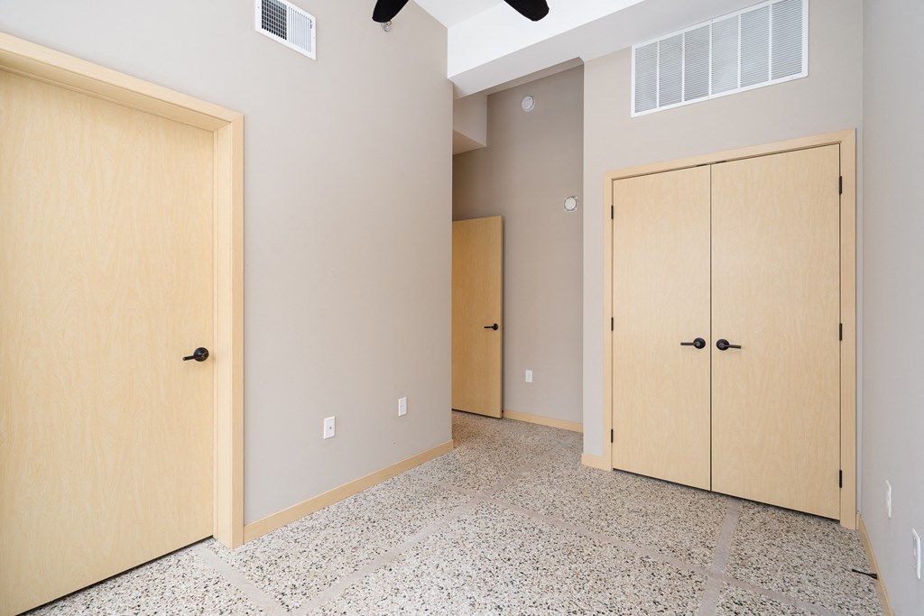 a bedroom with two closets and two doors
